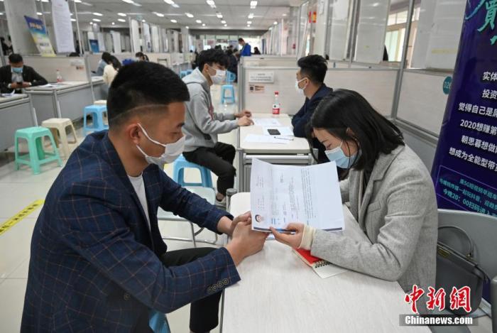 4月14日，招聘者在查看求職者簡(jiǎn)歷。<a target='_blank'  data-cke-saved- >中新社</a>記者 王剛 攝