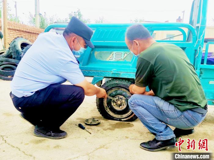賽旦與民警共同維修三輪摩托車?！∫懒窘?攝
