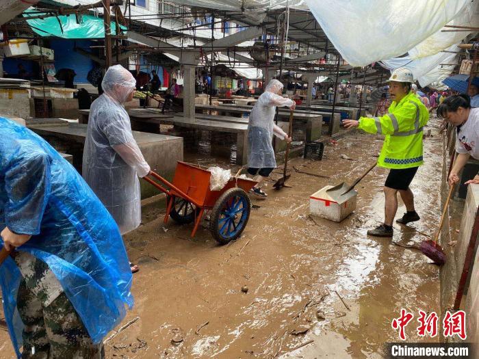 圖為7月26日，暴雨引發(fā)的洪水過境后，重慶萬(wàn)州區(qū)分水鎮(zhèn)政府干部職工及志愿者清掃淤泥和垃圾?！　≈貞c萬(wàn)州區(qū)委宣傳部供圖 攝